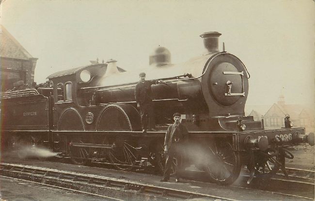 A Locomotive Train Postcard Showing Two Men standing Beside It