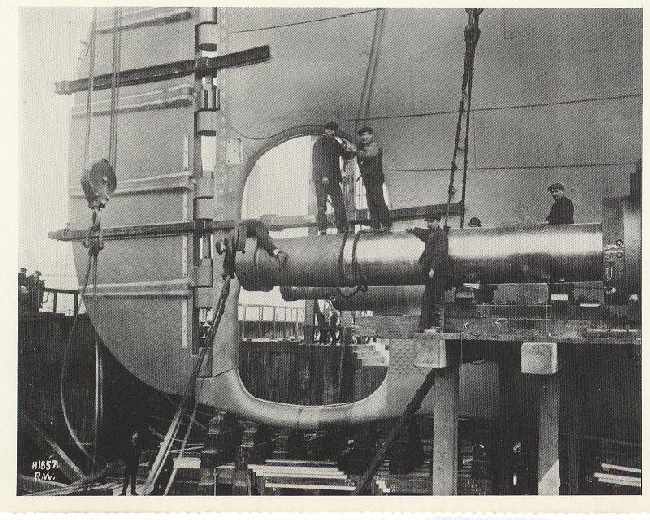 Workers fitting the Titanics propeller shafts into place. (1911)